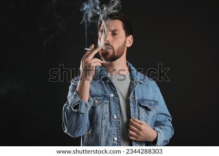 Man using cigarette holder for smoking on black background