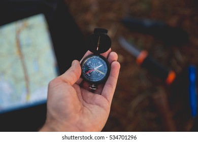 A man using a compass in the woods
