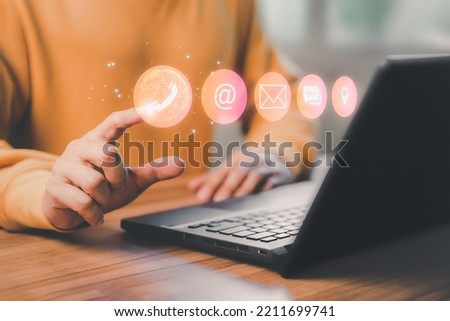 Man using a computer laptop and touching on technology virtual screen contact icons ( phone, email, address, live chat, map ). Contact us or Customer support hotline people connect.