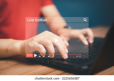 Man using a computer laptop for watching live football streaming online on virtual screen, searching video on internet, concept of content online.