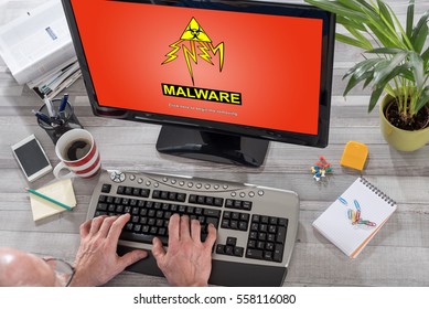 Man Using A Computer With Malware Concept On The Screen