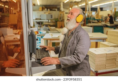 Man using computer on a cutting machine in a woodworking workshop - Powered by Shutterstock - Get 15% off with code: PIKWIZARD15