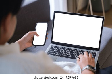 man using computer, smartphone white blank screen for hand typing text,using laptop contact business searching information in workplace on desk at office.design creative in livingroom.