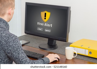man using computer with computer virus alert