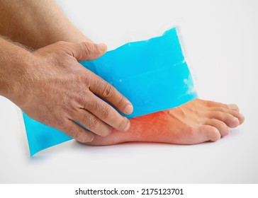 Man using cool gel pack on a swollen injured ankle with Color Enhanced skin with red spot indicating location of the pain isolated on white. Medical and health care concept photo. - Powered by Shutterstock