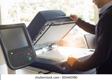 man using copier to make copies of document