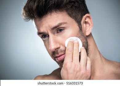 Man Using Cotton Pad On Face
