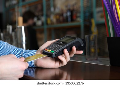 Man using credit card machine for non cash payment in cafe, closeup. Space for text - Shutterstock ID 1353002276