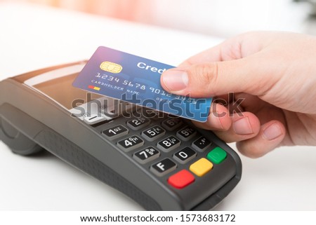 Man using credit card in shop. Cashless payment with pos terminal