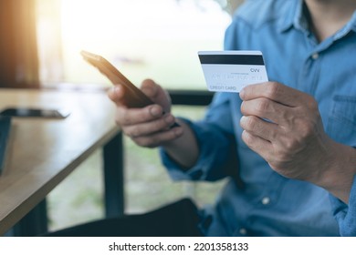 Man Using A Credit Card And A Smartphone To Log Into Internet Banking.Safe Online Payment Concept And Secure Electronic Money Transfer. Digital Payments, Financial Security To Protect Against Scams.