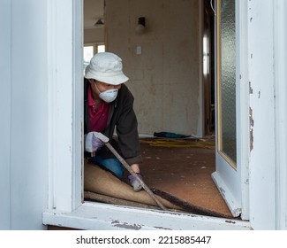 Man Using A Crowbar To Pull Up Old Carpet. Home Interior Do It Yourself Refurbishment Project.