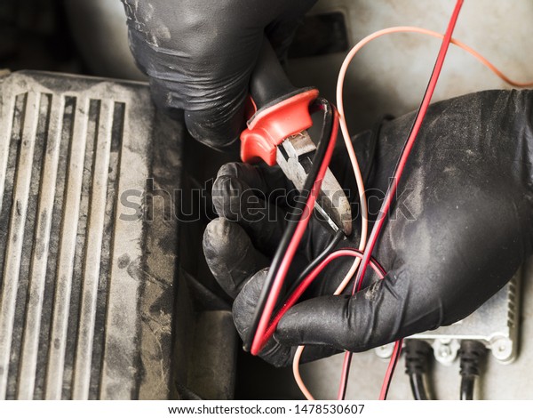 Man using cutters to cut\
wires
