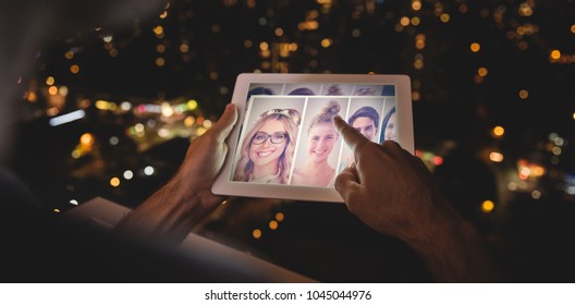 Man using digital tablet in the balcony against collage of portraits