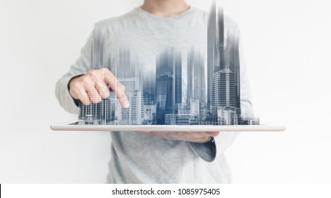 a man using digital tablet, and modern buildings hologram. Real estate business and building technology concept
