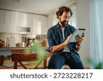 Man using a digital tablet for remote work or online entertainment in his kitchen