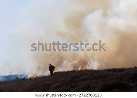 Man using a Drip Torch for controlled burning of Heather on moorland in County Durham, England, UK.