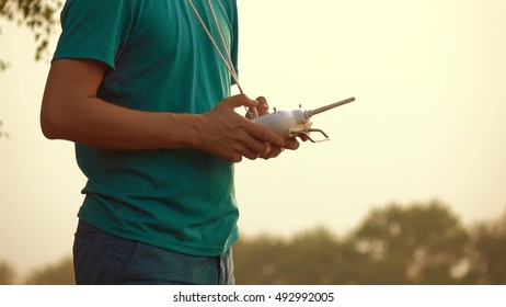 Man using drone RC remote at sunset