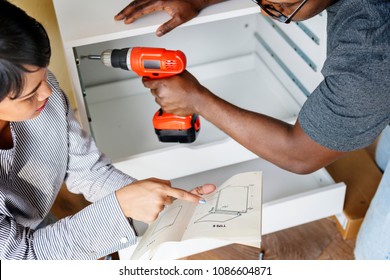 Man Using Electronic Drill Install Cabinet