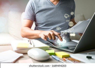 Man Using Fingers Point To Tablet Screen On The Wood Table With Communication Graphic Icons Popup In Cloud System Technology. Work From Home Or Remote Working