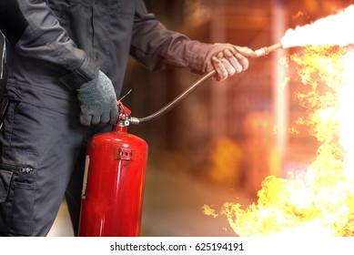 Человек с помощью огнетушителя тушения пожара крупным планом фото.