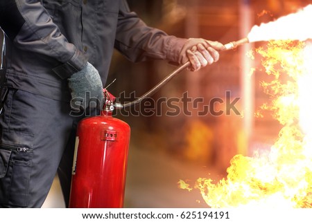 Man using fire extinguisher fighting fire closeup photo. Stockfoto © 