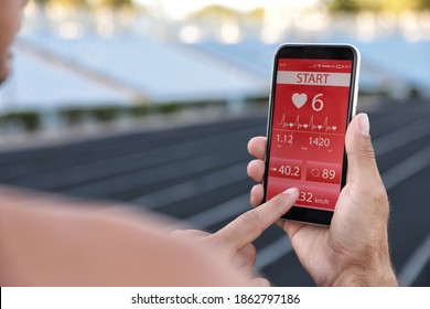 Man using fitness app on smartphone at stadium, closeup - Shutterstock ID 1862797186