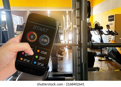 Man Using Fitness Tracker App On Smartphone with sunshine in Gym background. - Shutterstock ID 2168402641