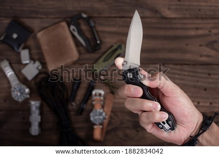 The man using folding knife. Close up folding knife in hand. EDC for men concept. 