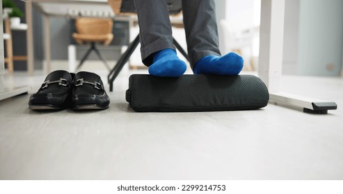 Man Using Footrest To Reduce Back Strain And Feet Fatigue