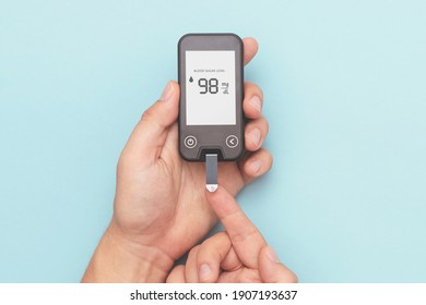 Man using glucometer, checking blood sugar level. Diabetes concept