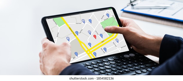 Man Using GPS Location Map Search On Tablet