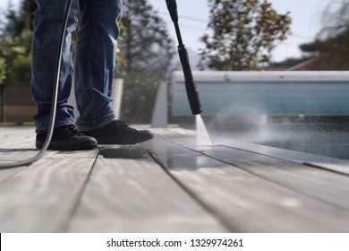 Man Using High Pressure Washer Cleaning Deck