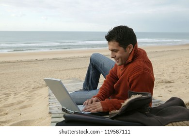 Man Using His Laptop At The Beach