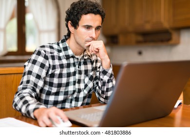 Man using his laptop computer at home - Shutterstock ID 481803886