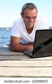 Man Using His Laptop On Jetty