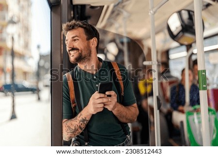 A man is using his phone in a public bus.