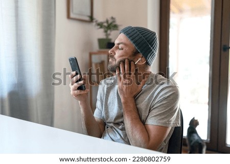 Man using his smart phone at home, everyday life with digital devices spending time on internet.