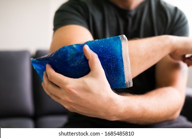 Man Using Ice Gel Pack On Injured Arm