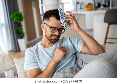 Man Using Ice Pack for Headache Relief, Migraine Treatment Concept. Sick Male Feeling Unwell and Suffering from Fever or High Temperature. Healthcare and Medicine Concept of Pain Management.