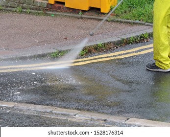 Man Using Jet Power Washer Hose To Clean Paint Off Road Surface. Road Cleaning With High Power Pressure Water Jet Hose