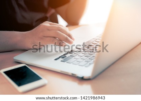 Man using labtop computer and smart phone for business, searching web, browsing information, having workplace at home / soft focus picture / Vintage concept