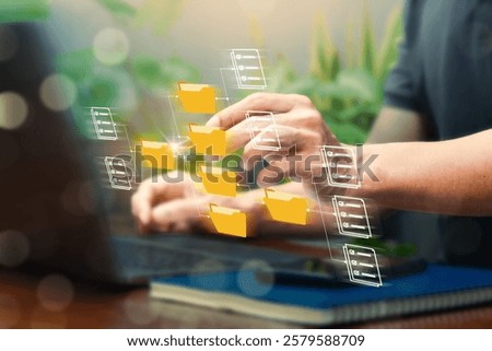 Man using laptop to access document information online through protection Document Management System (DMS) a digital file storage system data file management on virtual screen.