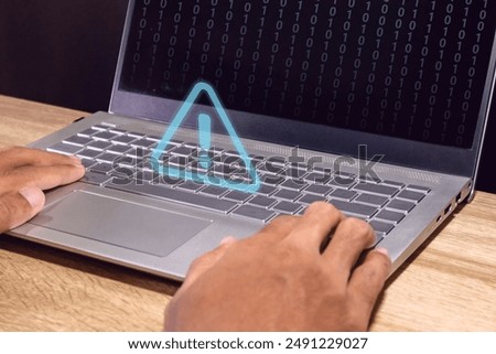 Man using a laptop with blue triangle caution warning sign for notification error, restricted content or maintenance concept