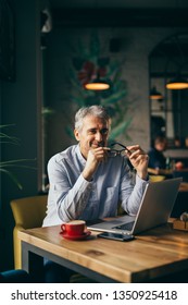 Man Using Laptop In Cafe Bar