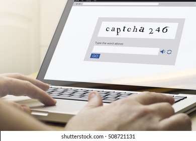 man using a laptop with captcha on the screen. Screen graphics are made up.