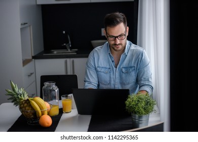 Man using laptop computer, working at home. Worried about finances.