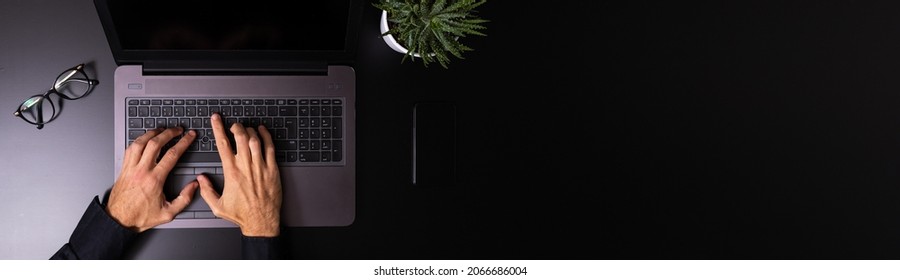 A man using laptop computer working on new project idea in the office late at night
