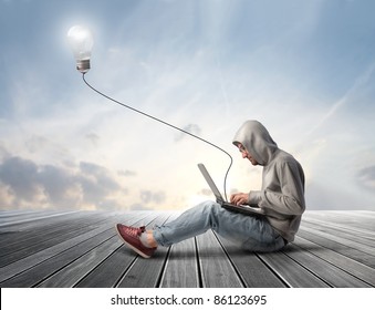 Man using a laptop with light bulb plugged in it