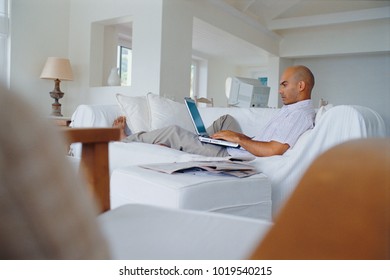 Man using laptop on couch