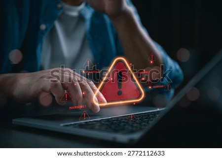 Man using laptop with red warning triangle icons and notification alerts. Conceptual image of cyber attack, system error, data breach, computer virus, and digital security risk management.